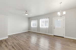 Entrance foyer featuring light wood finished floors, a ceiling fan, and hanging lights