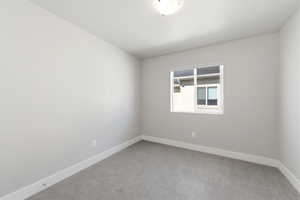 Empty room with light carpet and baseboards