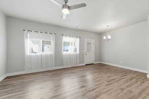 Unfurnished room with a ceiling fan, light wood-style floors, and hanging lights