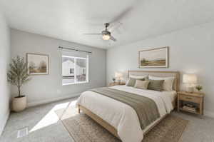 Carpeted bedroom featuring a ceiling fan with integrated lighting, a window with roller shades, and light-toned wall finishes