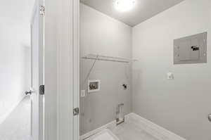 Laundry area featuring electric panel, hookup for a washing machine, a textured ceiling, and hookup for an electric dryer
