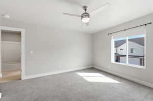 Spare room featuring ceiling fan and light colored carpet