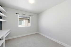 Empty room with baseboards and light colored carpet