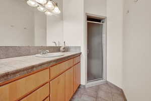Bathroom featuring vanity, a stall shower, and light tile patterned floors