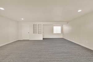 Empty room featuring dark carpet and recessed lighting
