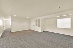 Unfurnished room with recessed lighting and dark carpet