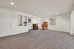 Sitting room with recessed lighting, built in features, and carpet floors