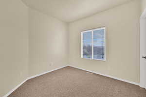 Carpeted spare room with baseboards