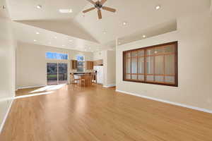 Unfurnished living room featuring light wood-type flooring, a ceiling fan, recessed lighting, and vaulted ceiling