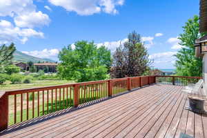 Wooden deck with a lawn and a mountain view