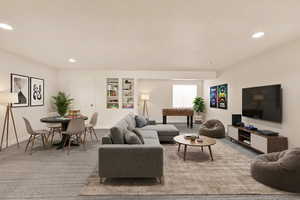 Carpeted living room with recessed lighting and built in shelves