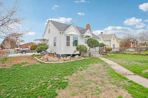 View of front of house featuring a chimney and a shingled roof
