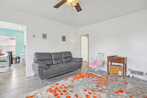 Living area with a ceiling fan and wood finished floors