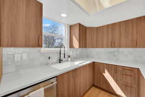 Kitchen with wood finish cabinetry, modern cabinets, and dishwasher