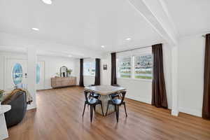 Dining room with light wood-type flooring, ornamental molding, and recessed lighting
