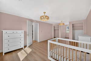 Hallway with light wood finished floors and ornamental molding