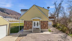 View of front of home featuring stone siding, french doors, entry steps, and a mountain view