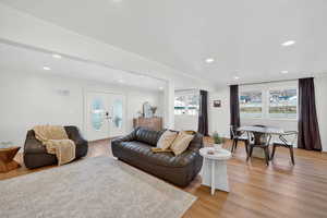 Living area featuring french doors, light wood-style floors, recessed lighting, and ornamental molding