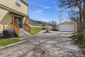 View of patio / terrace with a garage, an outbuilding, area for grilling, and a mountain view