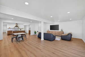 Living area featuring ornamental molding, recessed lighting, and light wood finished floors
