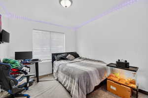 Bedroom featuring carpet and baseboards