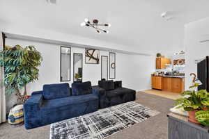 Living area featuring light carpet and baseboards