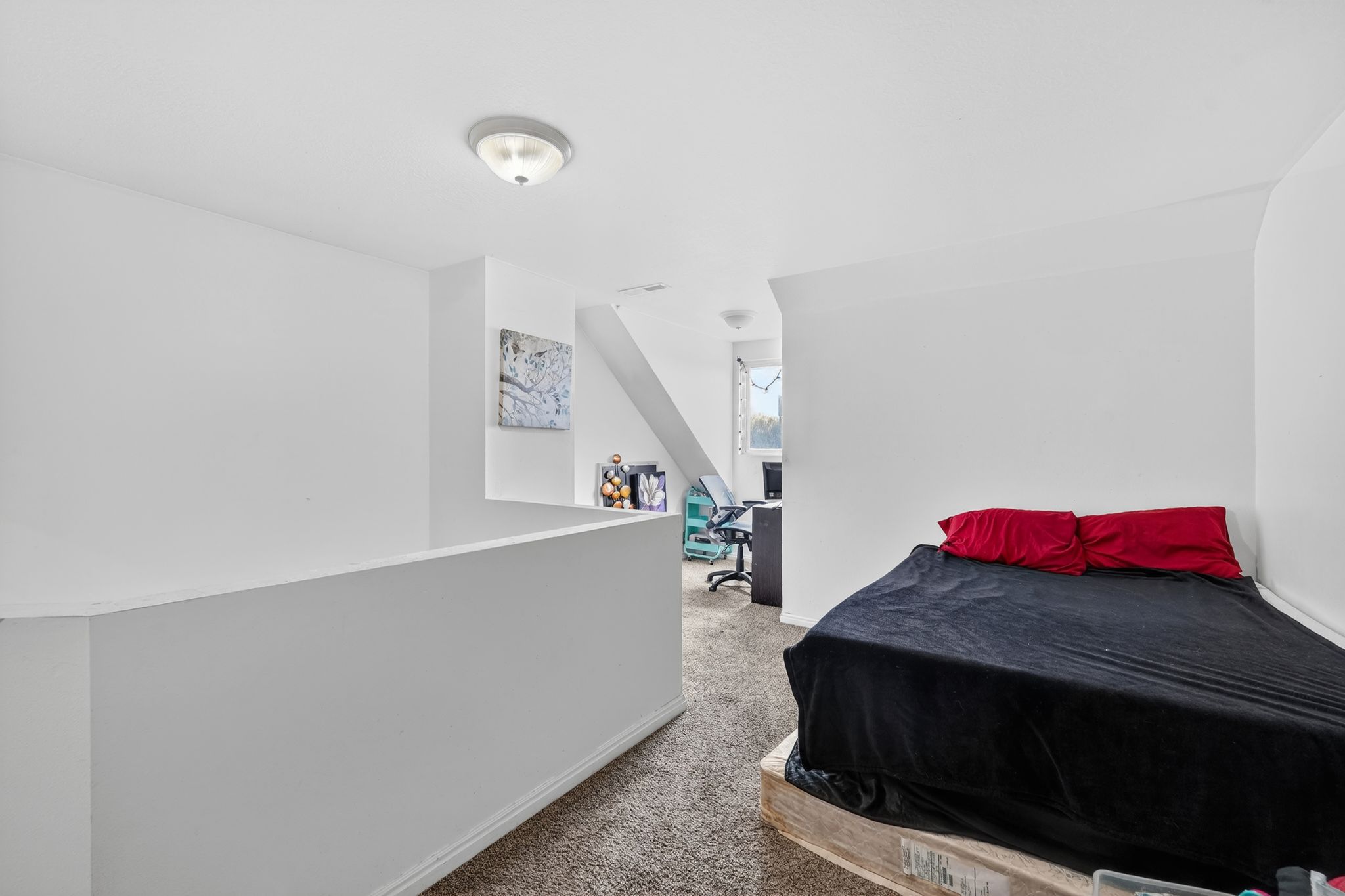 Bedroom featuring an office area and light colored carpet