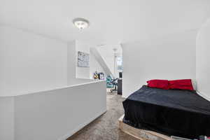 Bedroom featuring an office area and light colored carpet