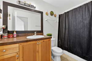 Full bathroom featuring vanity, light tile patterned flooring, and shower / bathtub combination with curtain