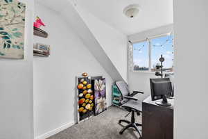 Office area with carpet floors and lofted ceiling