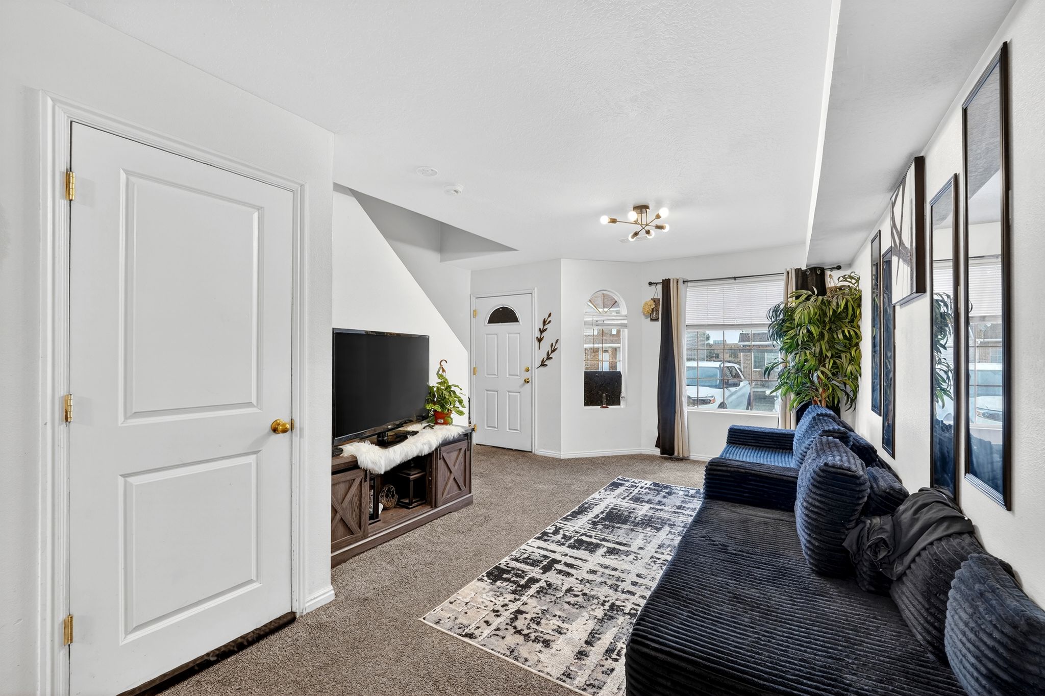 Living area with light colored carpet and a chandelier