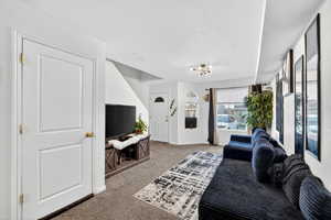 Living area with light colored carpet and a chandelier