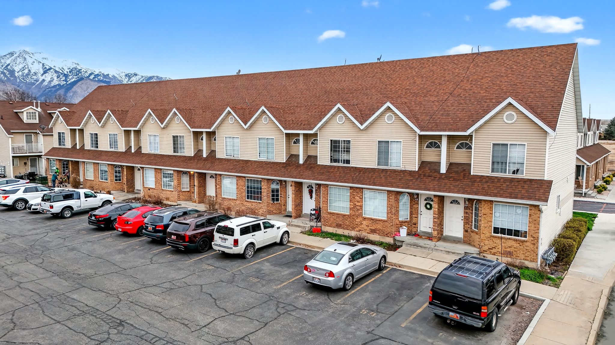 View of property with uncovered parking and a mountain view