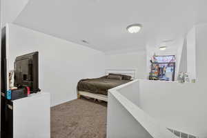 Bedroom with dark carpet and baseboards