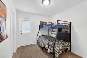 Bedroom featuring carpet and baseboards