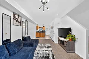 Living area with light carpet and hanging lights