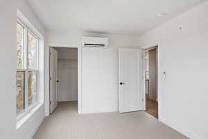 Unfurnished bedroom featuring light colored carpet and a spacious closet