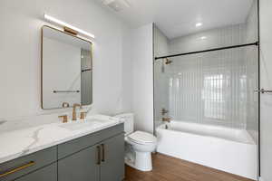 Full bath featuring vanity, shower / washtub combination, and dark wood-type flooring
