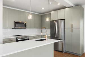 Kitchen with stainless steel appliances, hanging light fixtures, tasteful backsplash, light stone counters, and light wood-style flooring