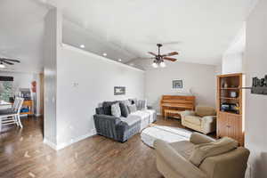 Living area featuring ceiling fan, vaulted ceiling, and wood finished floors