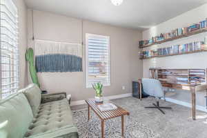 Home office featuring light colored carpet and baseboards