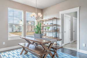 Dining space with wood finished floors and a chandelier