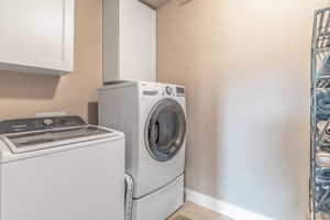 Laundry room with washer and clothes dryer and cabinet space