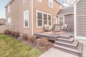 Wooden terrace featuring an outdoor lounge area and a lawn
