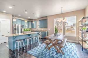Dining space featuring dark wood finished floors, suspended lighting, and a textured ceiling