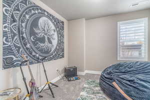 Bedroom featuring light carpet and a textured ceiling