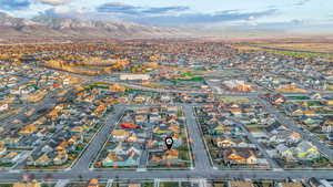 Aerial view of property and surrounding area with a mountainous background and nearby suburban area
