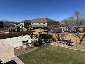 Fenced backyard with a patio, a gazebo, a fire pit, and a residential view