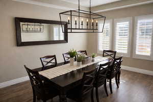Dining space with hanging lights and dark wood finished floors