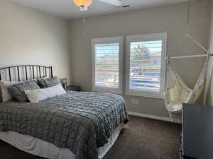 Bedroom with dark carpet and ceiling fan